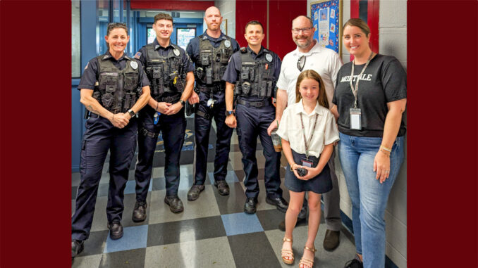 Montvale Police Capt. Alisha Foley, PO Glenn Moran, Lt. Kash Cruise, and Detective Sgt. Eric Robalino with Memorial Elementary School leaders — including principal for the day Olivia Koerner, rising third-grader, who escorted the officers on their Books and Badges tour May 28. Courtesy photo.