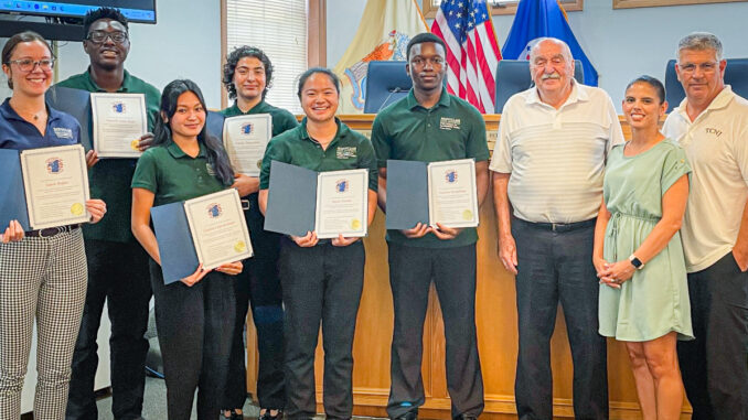 Interns from PSEG's Institute for Sustainable Studies Green Team, in partnership with Montclair State University, are thanked after their July 30 presentation on a flood mitigation study of the Township of Washington’s stretch of Musquapsink Brook. Left to right: Project manager Sara Reper, Montclair State University; Terrell Osei-Kyei, The College of New Jersey; Cayla Capistrano, Rutgers University; Emily Pazuello, Montclair State University; MeiLi Han, Hofstra University; Vinlaw Mudehwe, Case Western Reserve University; Councilman Tom Sears; councilwoman Daisy Velez; and council vice president Steven Cascio. Photo credit: Susan Witkowski.