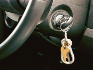 Shot of Car key and house key dangling from the ignition of car