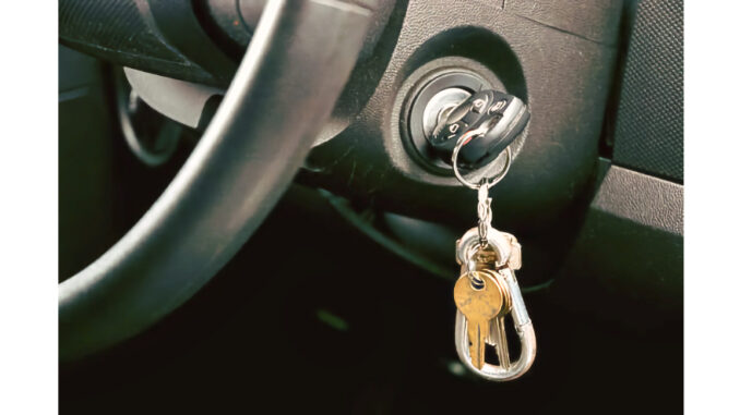 Shot of Car key and house key dangling from the ignition of car