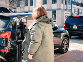 A driver feeds the meter on Westwood Avenue in late winter 2025. John Snyder.