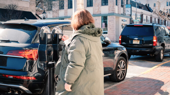 A driver feeds the meter on Westwood Avenue in late winter 2025. John Snyder.