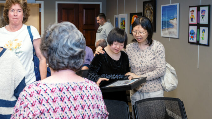 HAFA 9 Annie Fan feat Annie Fan, center, was one of many to answer the cal this year at the Hillsdale Access For All Fifth Annual Art Show For People With Disabilities. The reception was May 1 at Hillsdale Free Public Library, where the exhibition will run throughout May. John Snyder photo.
