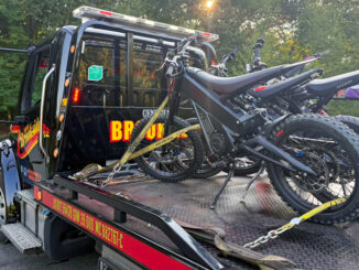 A row of dirt-bike–style electric motorcycles sits strapped to a flatbed after being impounded by Westwood police on Sept. 3. The department says throttle-only models without pedals require registration, insurance, and a licensed operator. (Courtesy Westwood Police Department)