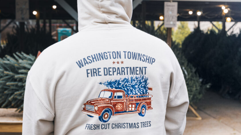 A Washington Township firefighter sports this year’s tree-sale hoodie during the department’s annual Christmas tree fundraiser at Memorial Field. John Snyder photo.