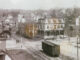 The Park Avenue railroad crossing in the 1910s. The road coming up from the bottom right corner is Broadway, then called Railroad Avenue, and it meets up with Park Avenue, which runs horizontally. At far left we see a portion of the Mittag & Volger typewriter ribbon factory. Behind where the men are standing is the Park Ridge train station. The three-story, Second Empire-style building across from Broadway was a hotel.