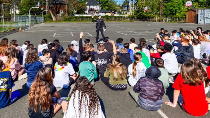 Hillsdale Police Patrol Officer Brianna DeGennaro speaks to students about e-bike and bicycle safety at a May 1 assembly at George G. White Middle School. Photo by Michael Olohan.