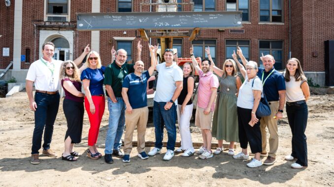 Focus on the future: Schools Superintendent Robert Lombardy, second from right, and district officials past and present after signing a ceremonial steel beam marking a milestone in the renovation and expansion of George G. White Middle School on July 24, 2026. John Snyder photo.