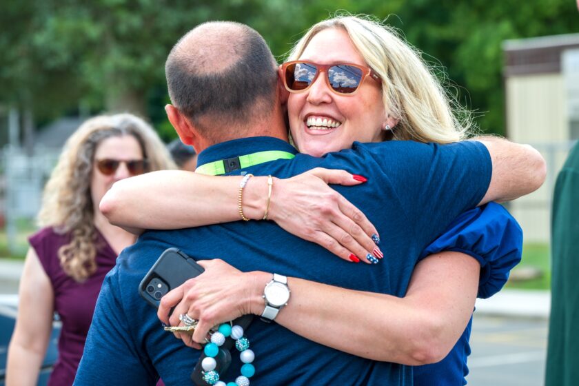 Former Hillsdale Board of Education trustee Shane Svorec embraces Superintendent Robert Lombardy in congratulations during the ceremonial beam signing at George G. White Middle School on July 24. John Snyder photo.
