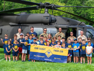 FRIENDS IN HIGH PLACES—Members of Township of Washington Cub Scout Pack 228 gather with New Jersey Army National Guard personnel in front of a UH-60 Black Hawk at Memorial Field on Aug. 22. The helicopter landing and public display anchored “Scouts Take to the Skies,” a community event celebrating aviation, service and Scouting. | Photo by John Snyder