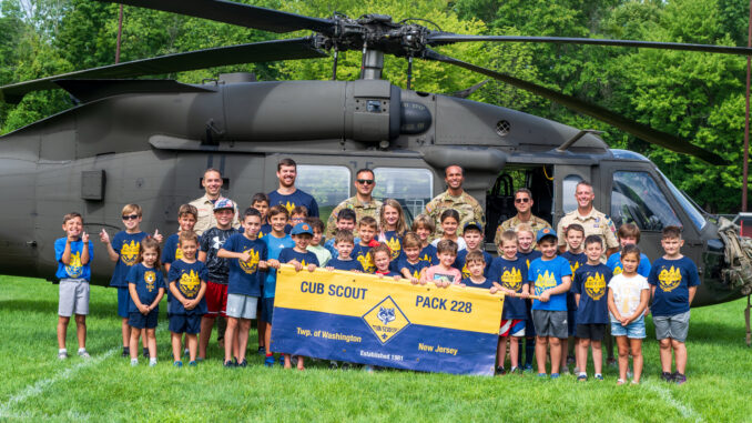 FRIENDS IN HIGH PLACES—Members of Township of Washington Cub Scout Pack 228 gather with New Jersey Army National Guard personnel in front of a UH-60 Black Hawk at Memorial Field on Aug. 22. The helicopter landing and public display anchored “Scouts Take to the Skies,” a community event celebrating aviation, service and Scouting. | Photo by John Snyder