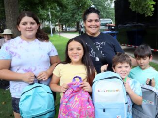 Children show off their backpacks at Englewood’s Back-to-School Splash at Mackay Park on Aug. 23. Students received backpacks filled with school supplies organized by grade. Hillary Viders photo.