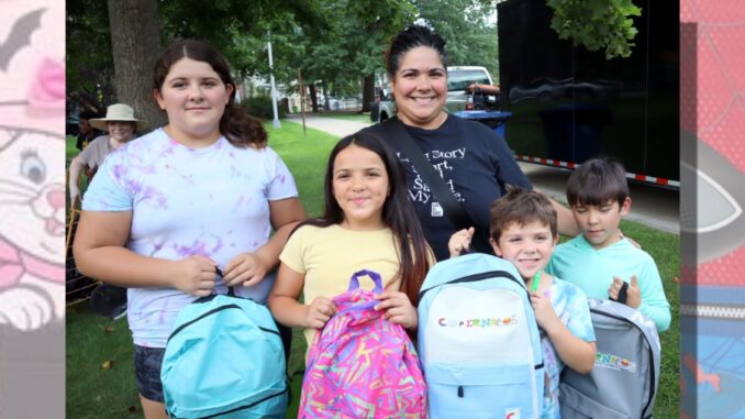 Children show off their backpacks at Englewood’s Back-to-School Splash at Mackay Park on Aug. 23. Students received backpacks filled with school supplies organized by grade. Hillary Viders photo.