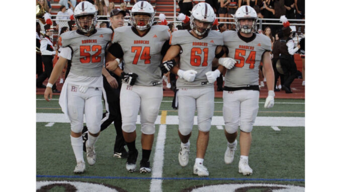 #4 Chase McDowell celebrates after his first varsity touchdown. Above: #52 Hudson Mahon, #74 Isaac Hsiao, #61 Luka Pinto, and #54 Mason Hennessy take the field as captains for the coin toss. Photo by Owen Baskin.